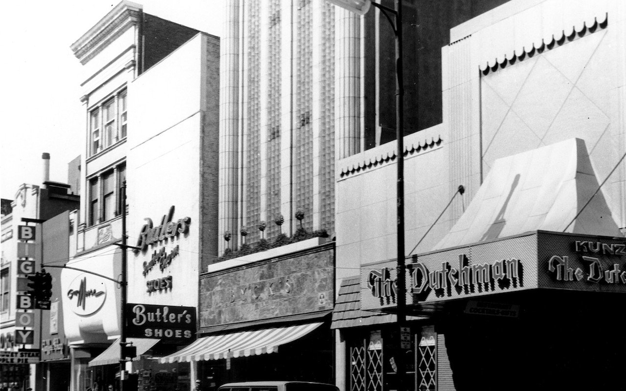 Front exterior of The Dutchman Restaurant, nestled among other businesses including Butler's Shoes and Big Boy coffee shop along south Fourth Street, Louisville, Kentucky. Image from the U of L Photo Archives.