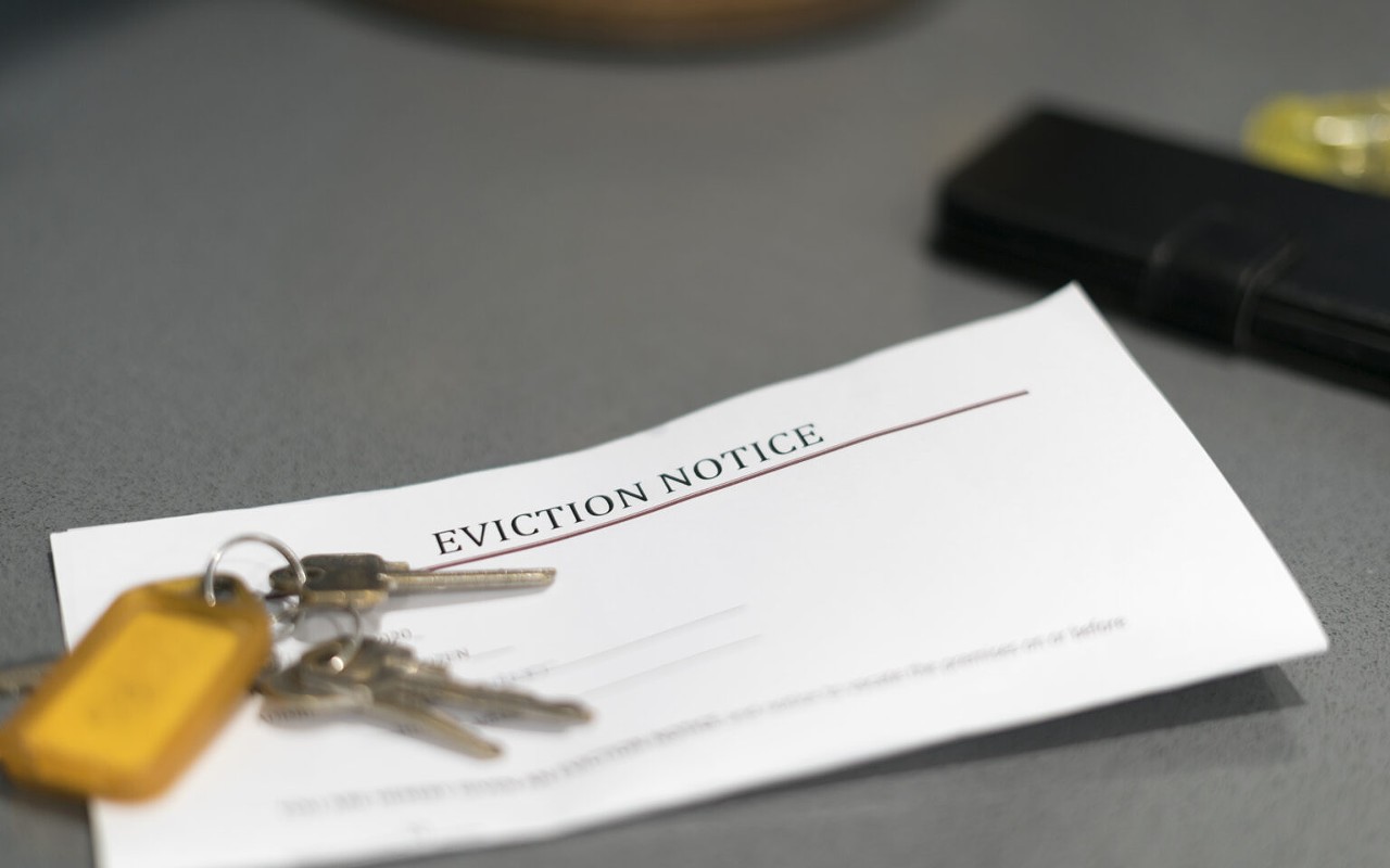 House keys sitting on an eviction notice received in the mail. rent assistance