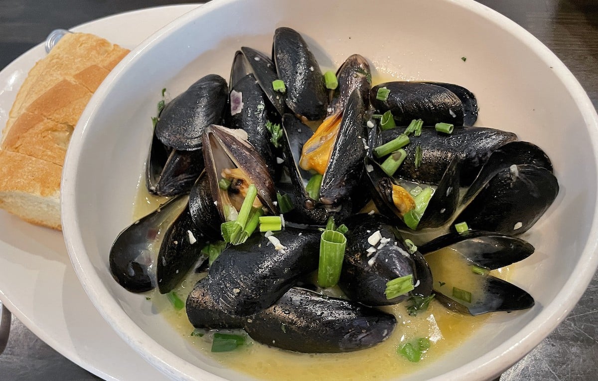 A large bowl of 16 mussels meuni&egrave;re comes swimming in a herbal, buttery traditional French white-wine sauce, with Italian-style bread to mop it up.