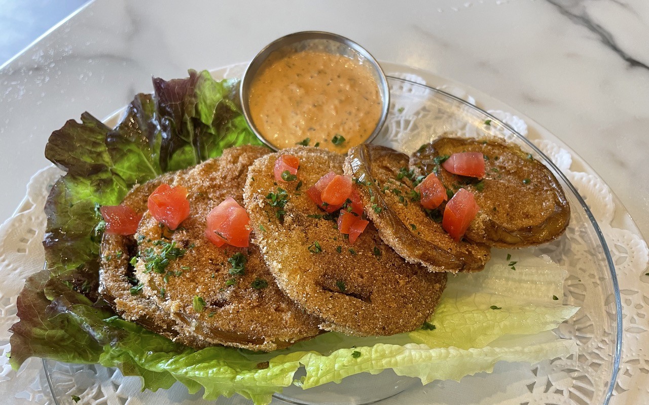 Fried green tomatoes are thin-sliced and very crisply fried in a crunchy cornmeal batter, with a spicy, cumin-laced red bell-pepper aioli alongside.