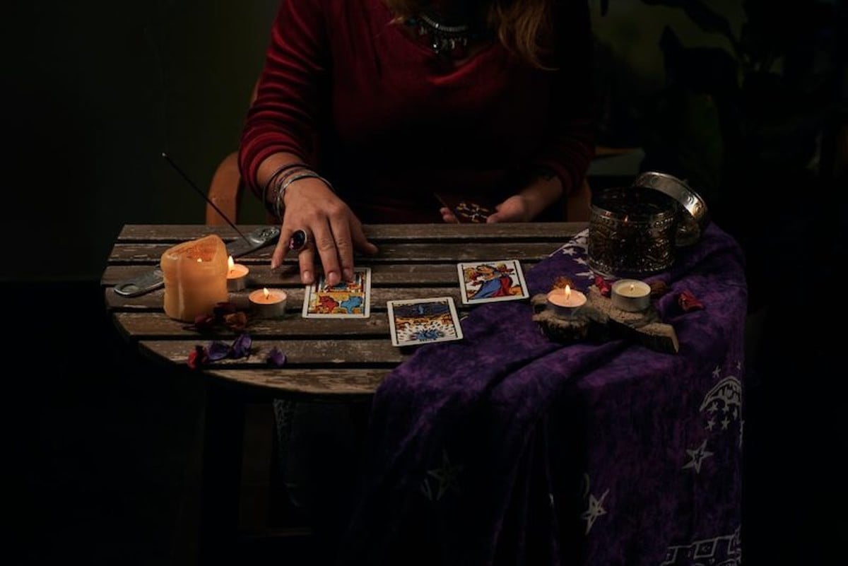 Tarot cards on a table with candles.