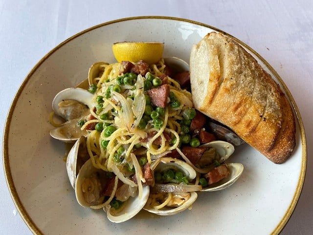 Tiny littleneck clams in the shell and spicy Portuguese lingui&ccedil;a sausage meet and mingle in this hearty spaghetti con vongole.