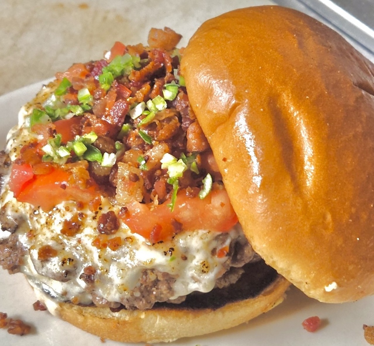 Dundee Tavern
KY Hot Brown Burger
Two beef angus patties with sharp cheddar cheese smashed and drizzled with scratch-creamy mornay sauce, topped with fresh diced tomatoes and bacon bits served on a brioche bun.