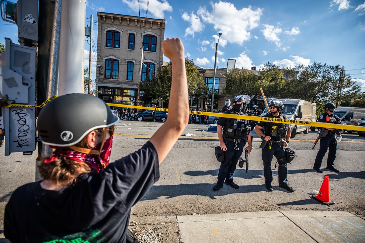 A protester raised their fist as police stood by after a large number of arrests were made following the Occupy NuLu call to action on Friday.