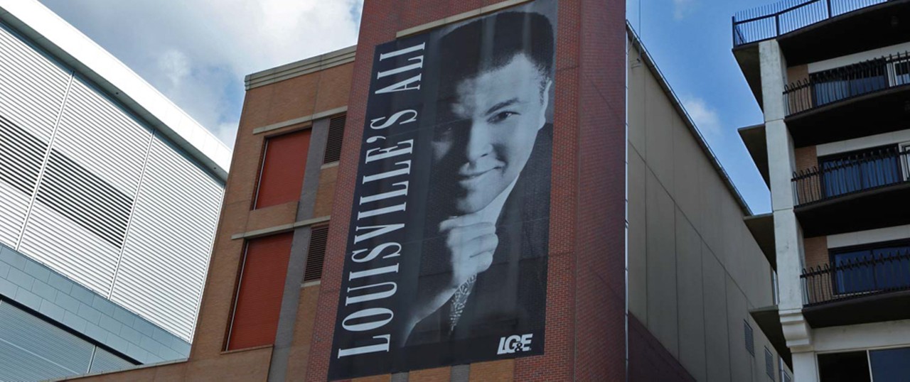 Oldest Hometown Heroes Banner: Muhammad Ali
3rd Street and River Road, facing the river
Put up: 2002 
The city&#146;s Hometown Heroes banners have honored many famous Louisvillians, including Jennifer Lawrence and Diane Sawyer, but the first belonged to none other than &#147;The Greatest,&#148; Muhammad Ali himself. His banner hangs on an LG&E building between the Yum! Center and the Galt House. It faces the Ohio River, where the Olympic champion Ali once tossed his gold medal after being refused service at a segregated restaurant.
Photo via the Hometown Heroes website