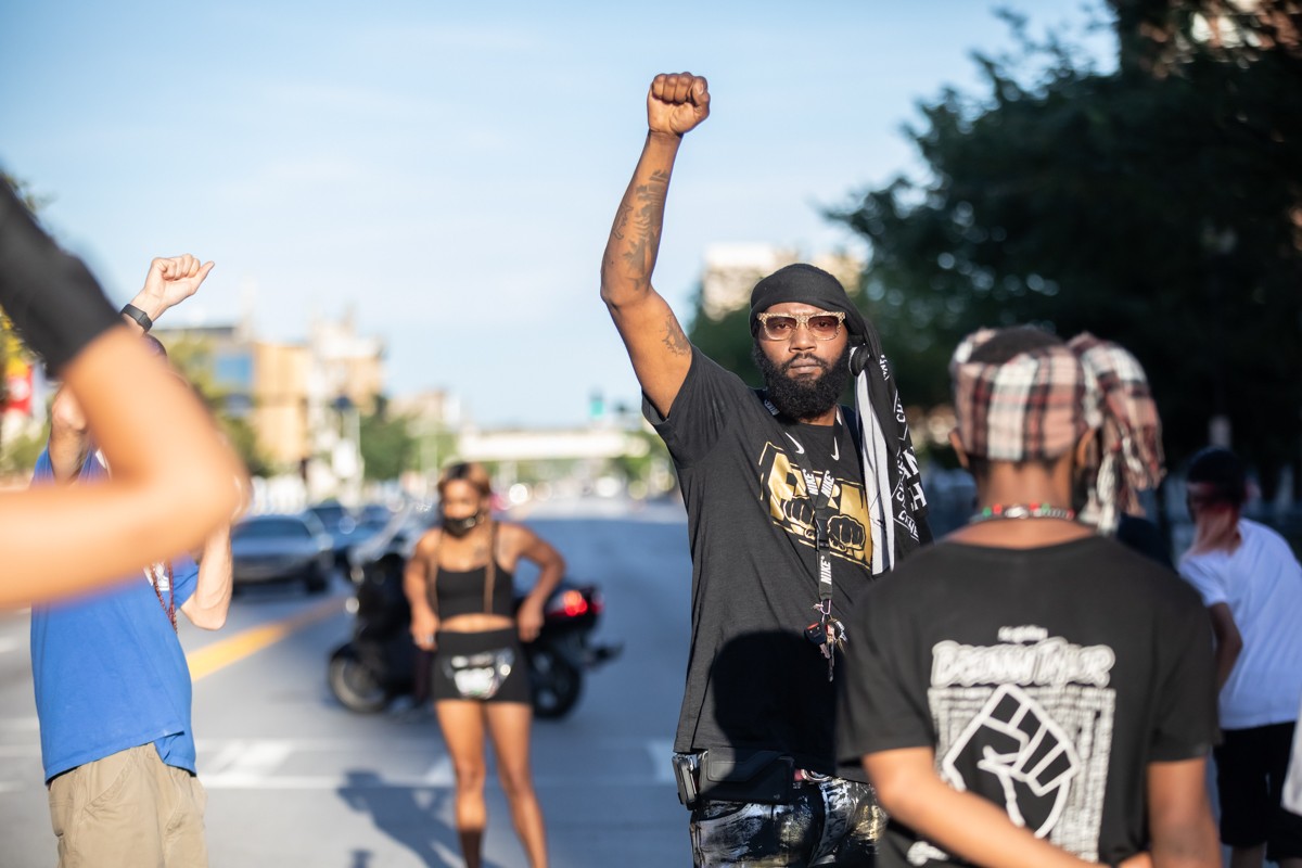 Chris Rashad held up his fist during the march towards the office of the Kentucky Derby Festival on Friday. - KATHRYN HARRINGTON