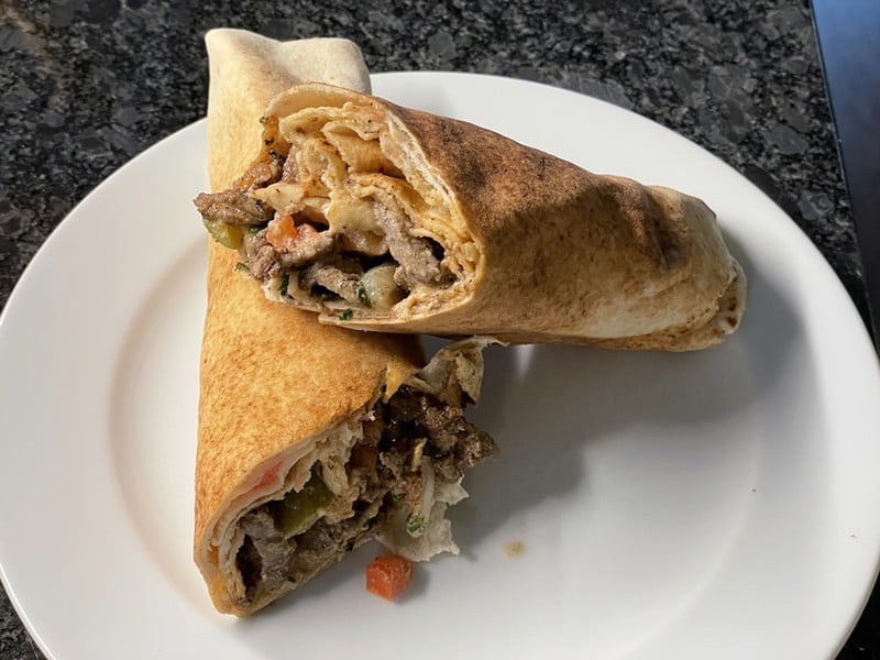 Shawarma loads thin-sliced flank steak, pickles and veggies into a paper-thin markouk flatbread roll.
