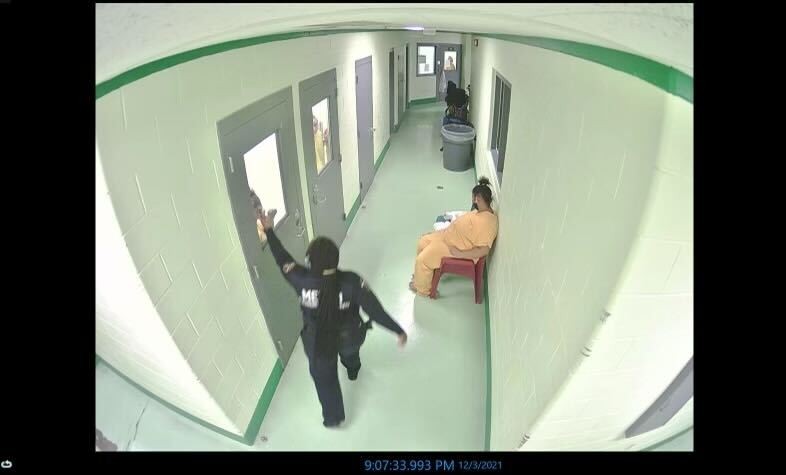 A security camera screenshot provided by attorney Trenton Burns shows an LMDC officer giving the middle finger to Dunbar after she was placed in an "attorney booth." - Trenton Burns