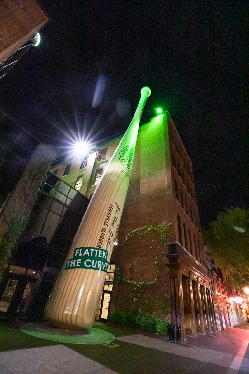 The world's largest baseball bat at the Louisville Slugger Museum is lit green and has a message to flatten the curve. - KATHRYN HARRINGTON