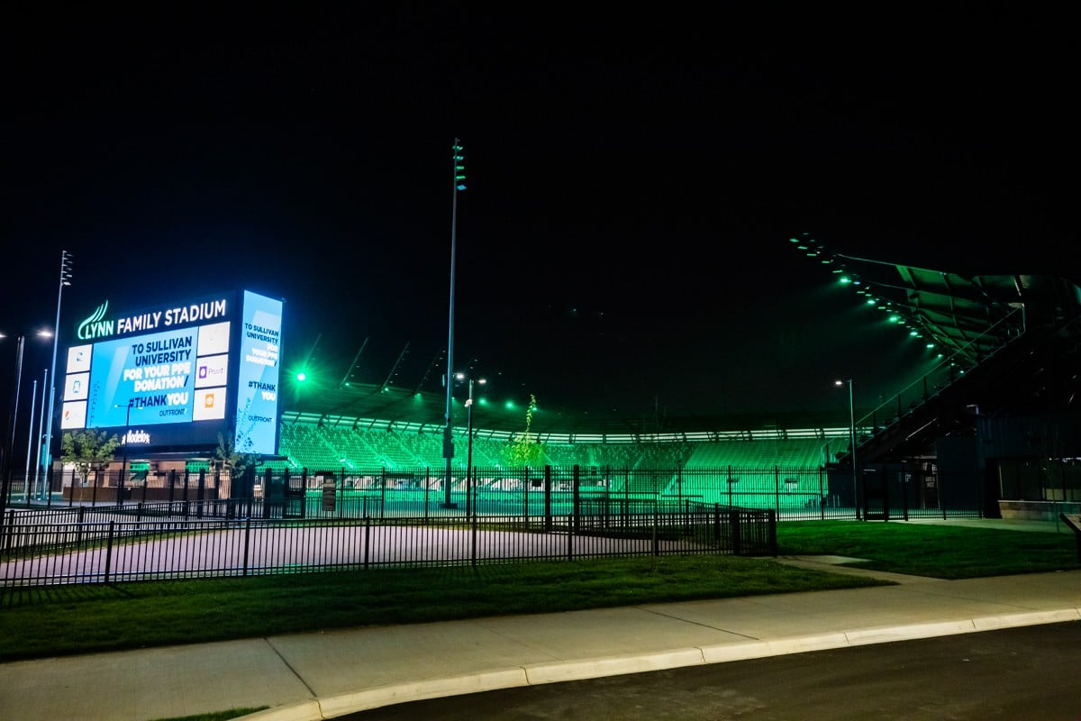 The Lynn Family Stadium glows green while its jumbotron displays messages related to the coronavirus. - KATHRYN HARRINGTON
