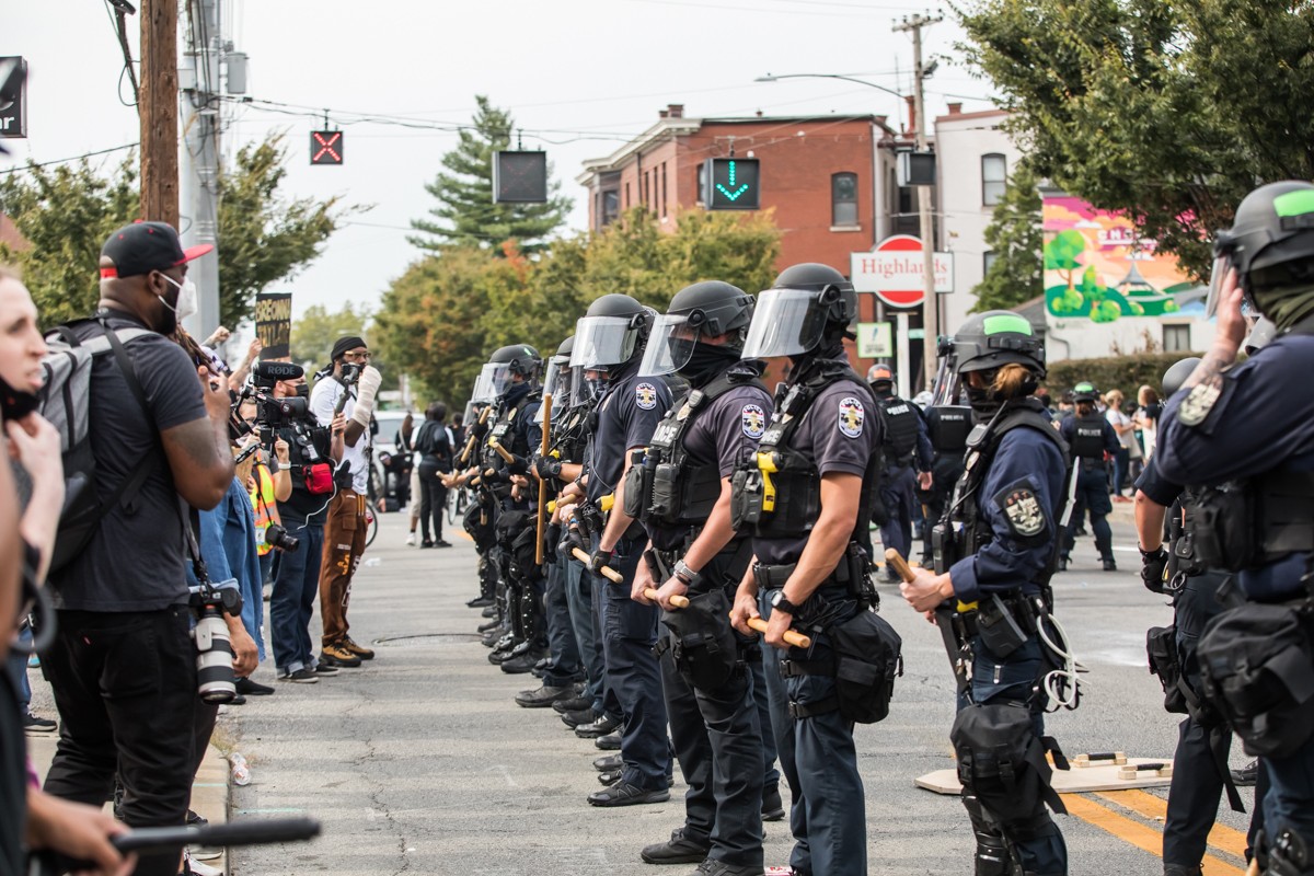 Polict in riot gear lined up along Bardstown Road after arresting several protesters. - KATHRYN HARRINGTON