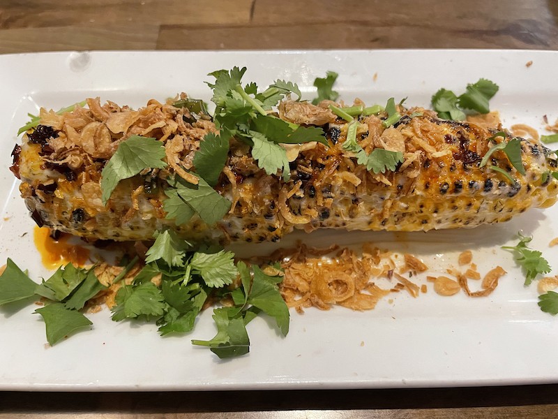 Vietnamese spicy street corn looks a lot like Mexican-style elotes, but it takes on a Southeast Asian accent with crispy shallots, fresh cilantro and a fiery burn.
