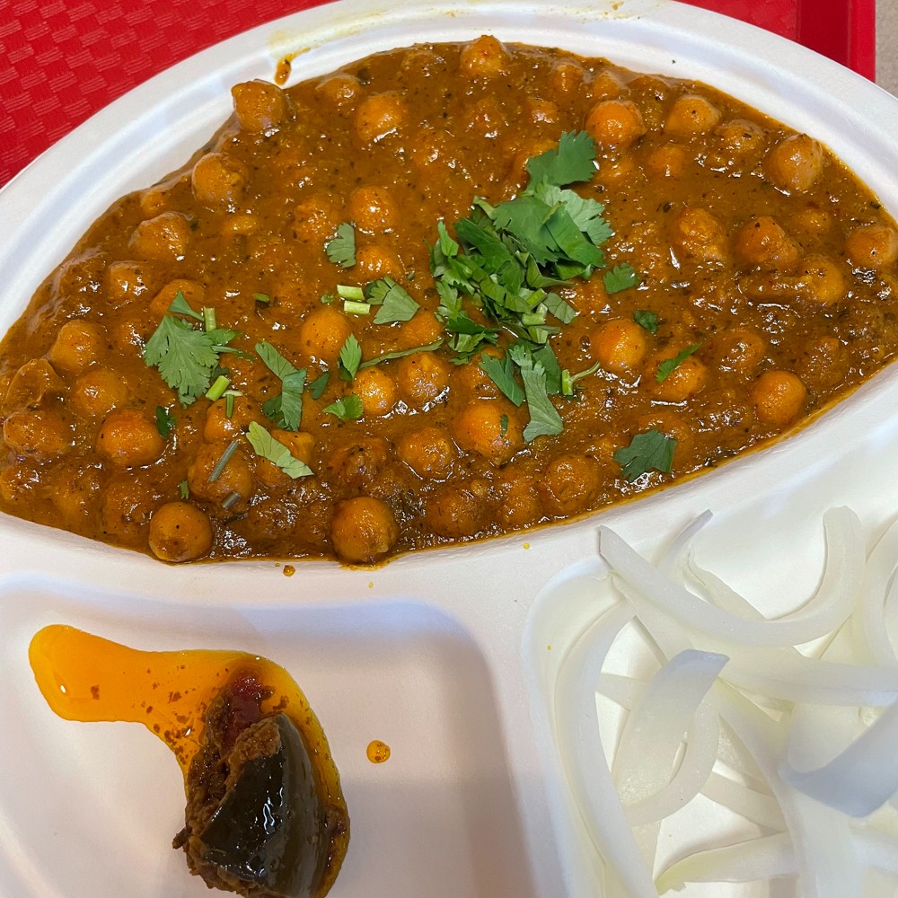 Chole bhature, a Punjabi dish on Shreeji's chaat menu, brings tender chickpeas in a spicy red chile sauce, with puffy fried puri bread alongside.