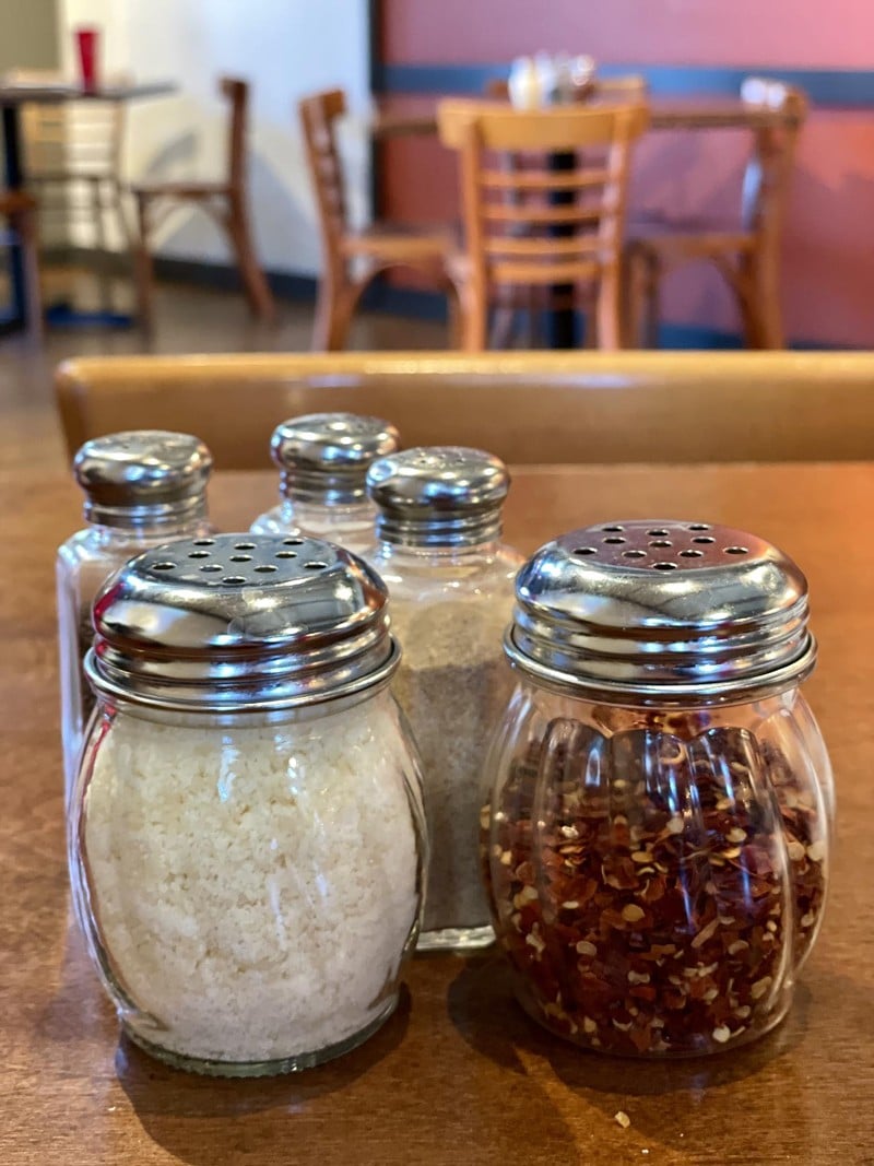 A full array of pizza condiments is available on every table: Red-pepper flakes, grated Parmesan, salt, pepper, and garlic salt! - Robin Garr